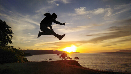 Man Silhouette Jumping into the sunset horizon