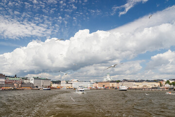 Helsinki, Finland, panorama of the Market Square Kauppatori in the port of Helsinki. Seagulls flying over water. View from sea.