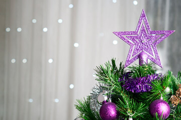 Christmas tree decorating with purple toys and star