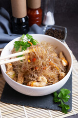 Funchosa with chicken on a slate stand. A dish of Asian cuisine.