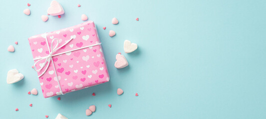 Valentine's Day concept. Top view photo of pink giftbox heart shaped marshmallow and sprinkles on isolated pastel blue background with empty space