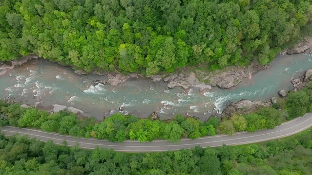Aerial view of Mountain river and road. Flying over a mountain gorge