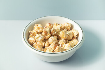 popcorn with butter caramel flavor on a white bowl and white background