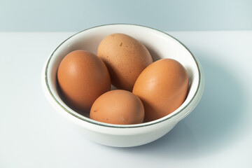 Chicken egg on white background and bowl
