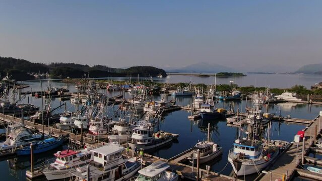 Marina Docks, Boats Docked Moored at Urban Port Harbor Quay in Juneau City Alaska During Beautiful Sunny Day, Aerial Flyover
