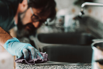 Close up view of man cleaning hard the kitchen surface at home in female usually work activity....