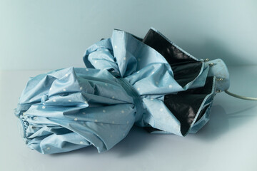 small blue folding umbrella on a white background