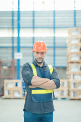 The male commander's smile stood in the warehouse with his arms crossed, looking at the camera. Logistics industry concept.