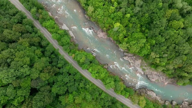 Aerial view of Mountain river and road. Flying over a mountain gorge