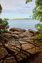 Rocky surface with large cuts in all directions overlooking lake on cloudy day