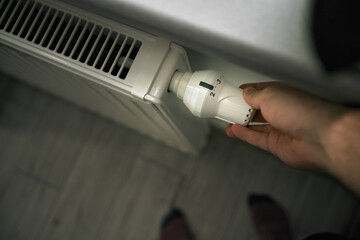 Cutting heating costs in households during the energy crisis. Close-up of heating thermostat in the minimalistic interior.