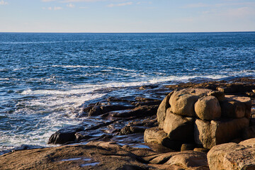 Waves along ocean coast of Maine with boulder formations