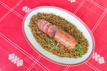 Cotechino (pork sausage) with lentils. Traditional Italian dish.  According to tradition, it is served with lentils on New Year's Eve, because it is said that lentils bring money for the coming year