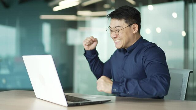 Overjoyed business man IT programmer extremely happy after read email message on laptop at modern workplace Excited employee look at screen and pleased rejoices received great news on computer indoor