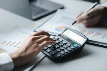 A female financier is reviewing company financial documents, monthly financial statement summary from the finance department. The concept of managing the company's finances for accuracy and growth.