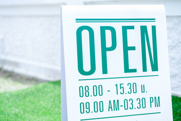 White shop opening sign on the road