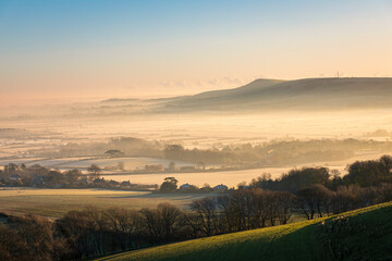 Naklejka na ściany i meble Misty December morning over the river Ouse valley between Kingston Ridge and Firle Beacon on the south downs east Sussex south east England UK
