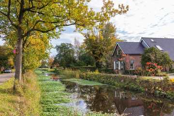 Fototapeta na wymiar Street view with canal in De Wilp municipality Westerkwartier in Groningen province The Netherlands