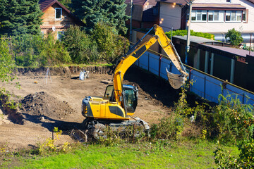 An excavator digs the ground on the construction site 