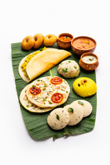 South Indian Masala Dosa, Uttapam, Idli vada sambar, semolina halwa, upma served over banana leaf