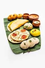 South Indian Masala Dosa, Uttapam, Idli vada sambar, semolina halwa, upma served over banana leaf