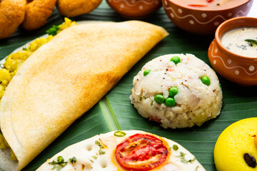 South Indian Masala Dosa, Uttapam, Idli vada sambar, semolina halwa, upma served over banana leaf