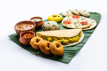 South Indian Masala Dosa, Uttapam, Idli vada sambar, semolina halwa, upma served over banana leaf