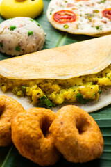 South Indian Masala Dosa, Uttapam, Idli vada sambar, semolina halwa, upma served over banana leaf