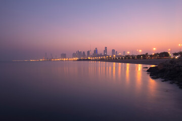 View of the Kuwait skyline - with the best known landmark of Kuwait City - during sunrise and beach view. Kuwait city skline from bridge with slow shutter speed.