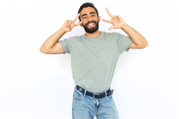 Joyful man making victory gesture. Young male model showing peace sign with both hands. Portrait, studio shot, success, peace concept