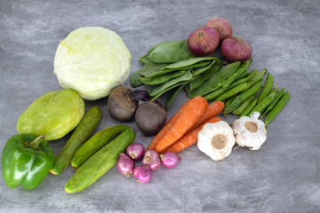 Organic fresh vegetables in isolated background. Close up view of fresh organic vegetables cabage, carrot, big red onions, small red onions, cucumbers, bell pepper - capsicum , beetroots , beans