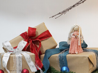 self made angel doll and Christmas gifts. Christmas presents with ribbon around brown wrapping paper