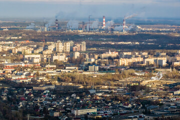 Fototapeta na wymiar ariel panoramic view of city with huge factory with smoking chimneys in the background