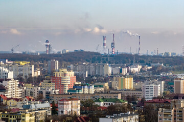 ariel panoramic view of city with huge factory with smoking chimneys in the background
