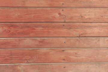 Naklejka premium A hardwood aged wall background. Wooden red planks, a texture of a natural tree.