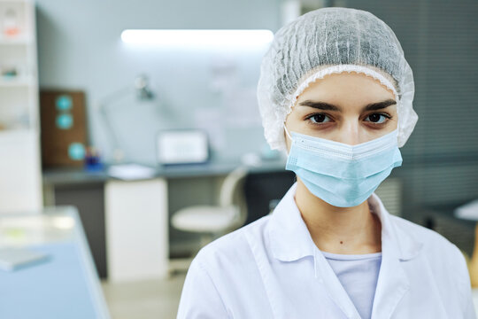 Portrait Of Young Woman Wearing Face Mask Looking At Camera In Medical Lab, Copy Space