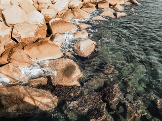 Seashore with large boulders. Rocky shore with clear blue water. Mediterranean Sea coast, Cyprus.