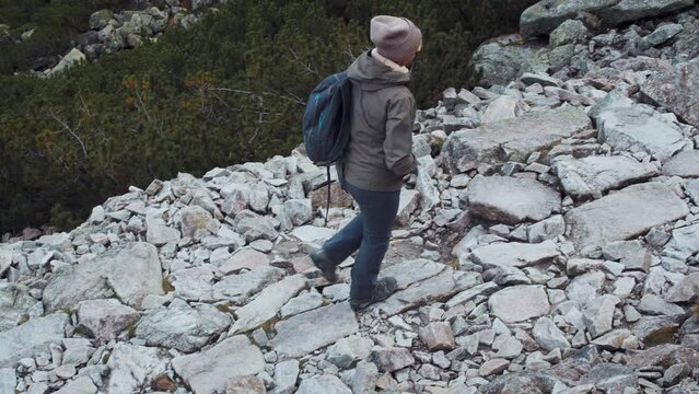 Mountain rocky path. A woman travels in the mountains. Hiking. Active tourism. Visit new places. Journey through the Alps.