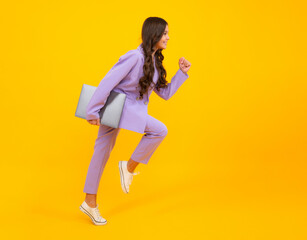 Teenager school girl hold notebook laptop. Run and jump, jumping kids. School children on isolated studio background.