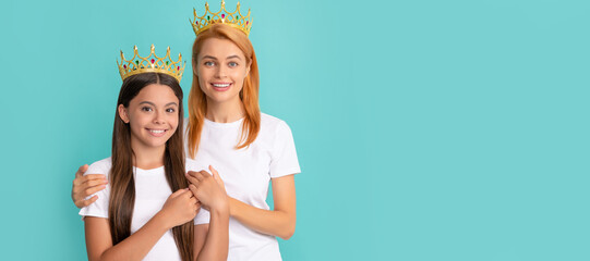 Mother and daughter child banner, copy space, isolated background. Happy woman mother hug daughter child wearing crowns blue background, prom.
