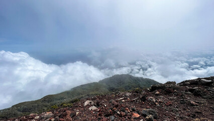 Panorama of flowing fog waves on mountain tropical rainforest, image over the clouds Amazing nature background with clouds and mountain peaks in Purbalingga.