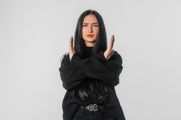 Portrait of brunette young woman hold hands crossed angry mood, standing over white studio background. Serious student girl refusing something