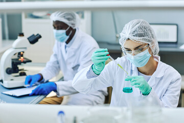 Portrait of young female worker in laboratory doing medical research, copy space