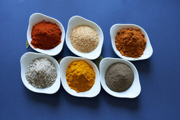 Spices for cooking fish dishes on a blue background.