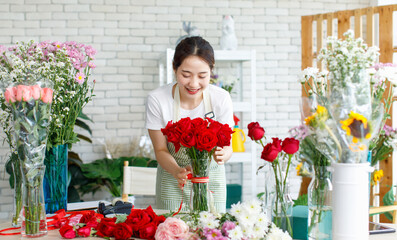 Millennial Asian young beautiful professional female flower shopkeeper owner decorator florist...