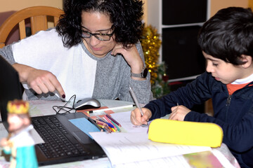 Naklejka premium photograph of a young mother doing homework with her child. selective focus