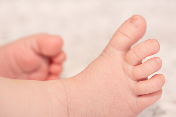 Close-up of a newborn baby's toes.  Close-up of a newborn baby's foot. The little leg of a white baby.  A tiny baby foot. Healthy and clean skin of a small child's leg.