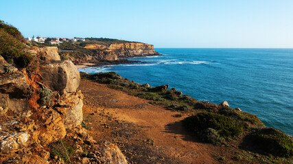 Beautiful natural landscape with ocean rocky shore with blue sky.  Scenic ocean  landscape on summer sunny day.  Beautiful  rocky coast at Santu Isidoro. Portugal. Europe.