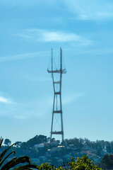 Sutro tower in shadow with urban and suburban foreground with clear blue sky background some clouds in the city neighborhood