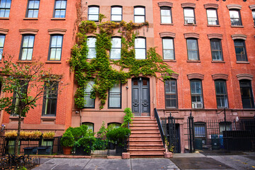 View outside beautiful apartment building with red bricks and green vines in Greenwich Village New York City